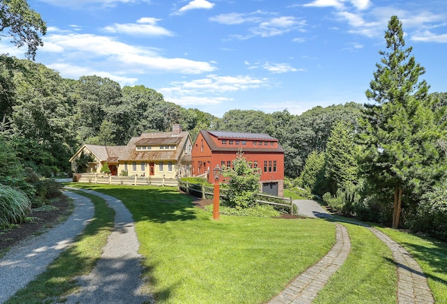 44 Brook St, Groton, CT 06340 - view of front of house featuring a front yard, fence, a wooded view, and a chimney