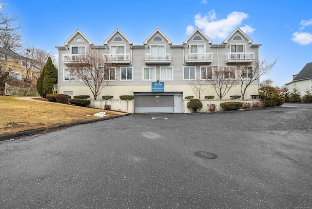 view of front facade with aphalt driveway and an attached garage