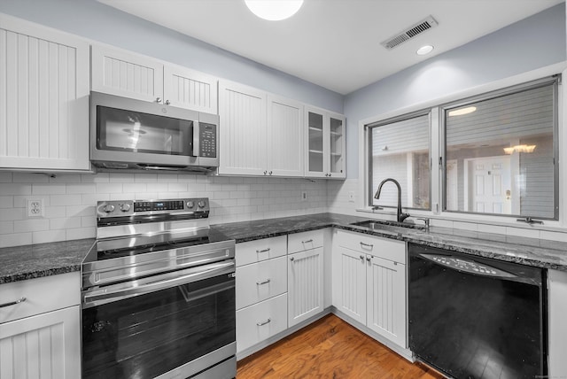 kitchen with visible vents, appliances with stainless steel finishes, a sink, light wood-type flooring, and backsplash