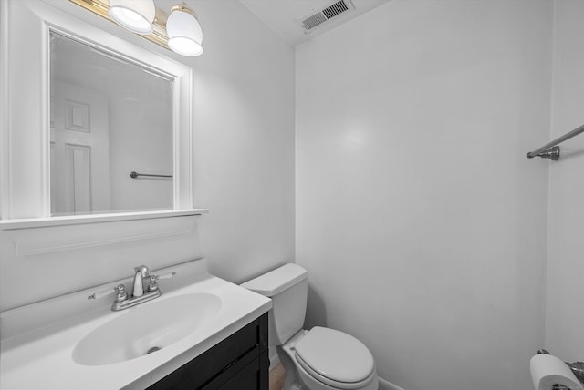 half bath featuring visible vents, vanity, and toilet