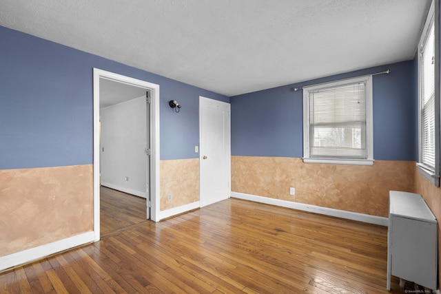 empty room featuring hardwood / wood-style flooring and a textured ceiling