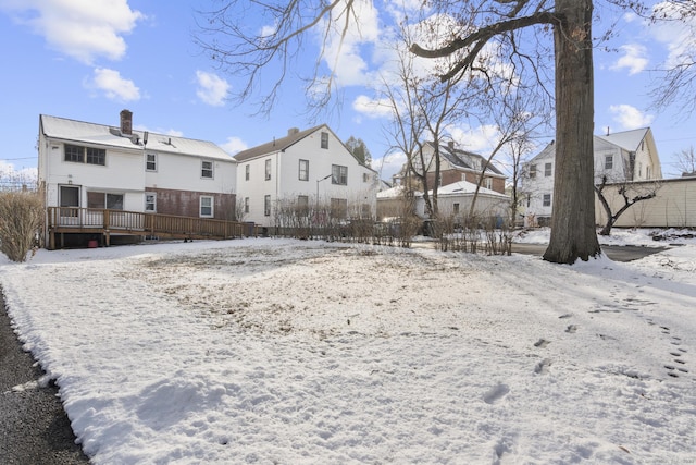 snow covered house with a wooden deck