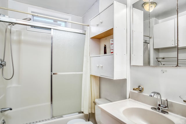 full bathroom featuring enclosed tub / shower combo, vanity, and toilet