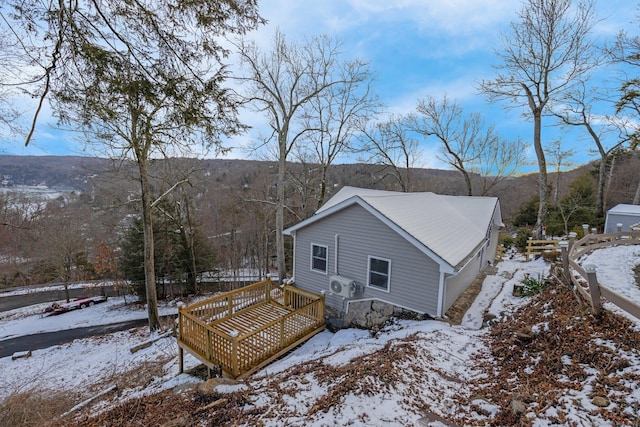 view of snow covered exterior with a deck with mountain view