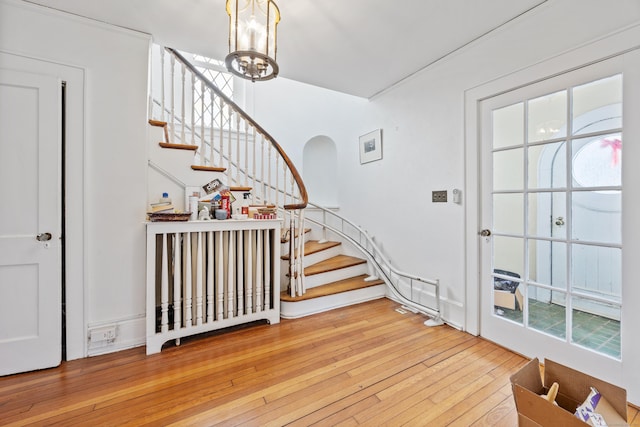 entrance foyer with wood-type flooring and a chandelier