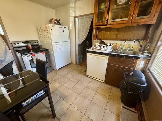 kitchen featuring sink, tile countertops, white appliances, and light tile patterned floors