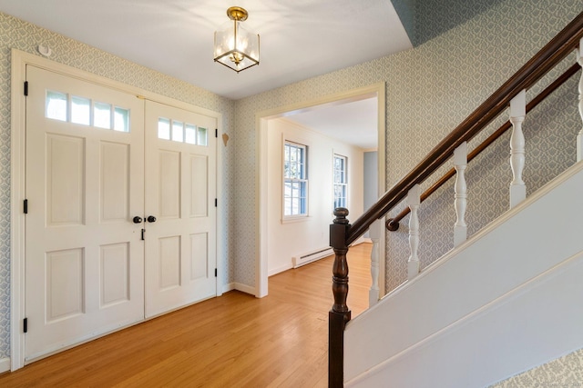 foyer with a baseboard radiator and light wood-type flooring