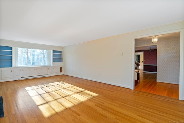 unfurnished room featuring wood-type flooring, a baseboard heating unit, a notable chandelier, and built in shelves