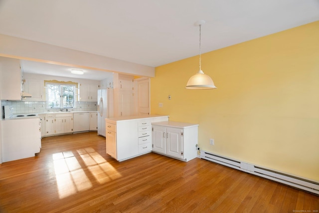 kitchen with hanging light fixtures, white appliances, a baseboard radiator, and white cabinets