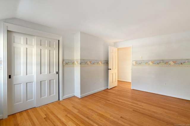 spare room with vaulted ceiling and light wood-type flooring