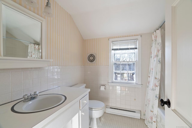 bathroom featuring tile walls, vanity, baseboard heating, toilet, and tile patterned floors