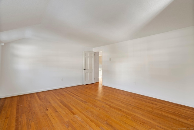 unfurnished room with lofted ceiling and light hardwood / wood-style flooring