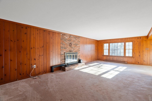 unfurnished living room featuring crown molding, light carpet, baseboard heating, wooden walls, and a fireplace