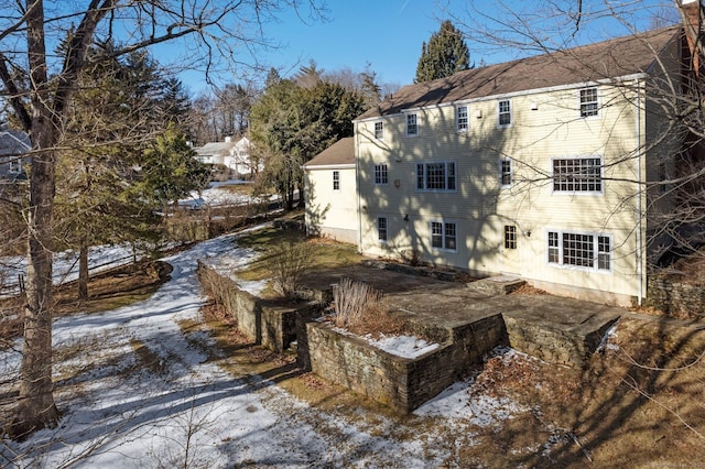 view of snow covered rear of property