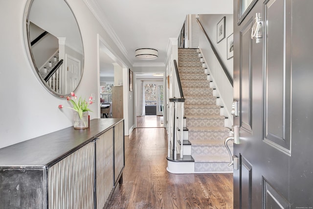 foyer entrance featuring stairway, ornamental molding, and dark wood finished floors