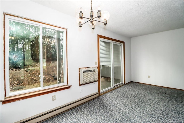 carpeted spare room featuring a notable chandelier, a wall unit AC, a textured ceiling, and baseboard heating