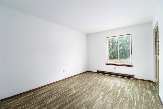 unfurnished room featuring baseboard heating and carpet floors