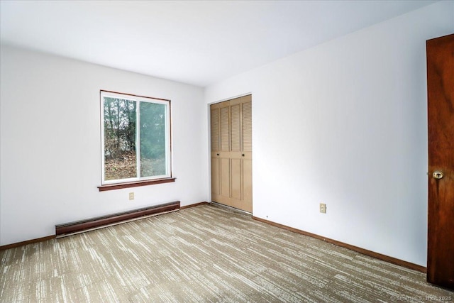 carpeted spare room with a baseboard radiator