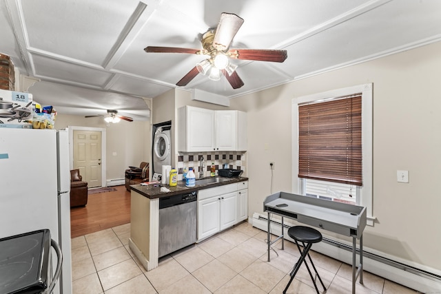 kitchen with white cabinetry, a baseboard radiator, appliances with stainless steel finishes, and stacked washer / dryer