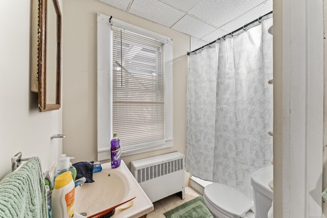 bathroom featuring toilet, a paneled ceiling, vanity, radiator, and tile patterned flooring