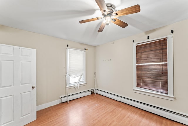 spare room with ceiling fan, light hardwood / wood-style flooring, and a baseboard heating unit