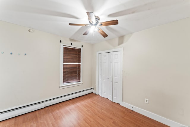 unfurnished bedroom featuring light hardwood / wood-style flooring, a baseboard radiator, a closet, and ceiling fan