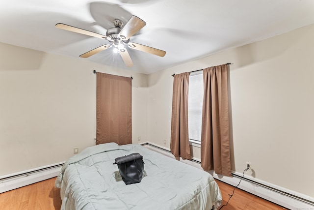 bedroom with ceiling fan, light wood-type flooring, and baseboard heating