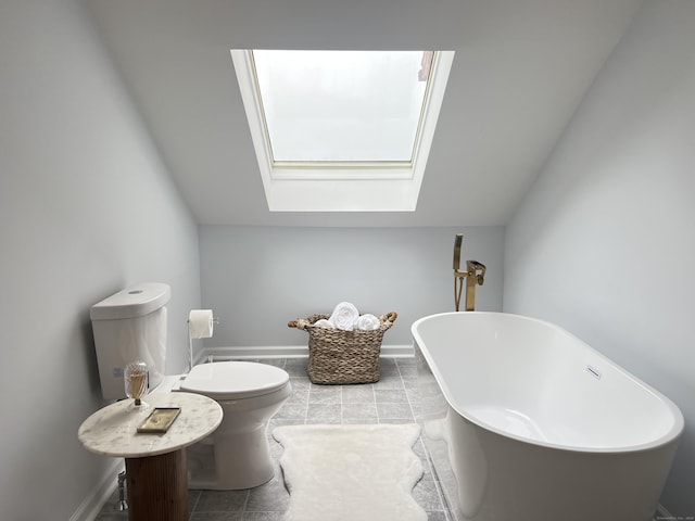 bathroom featuring tile patterned flooring, vaulted ceiling with skylight, a tub, and toilet