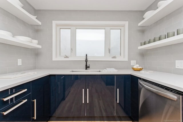 kitchen with tasteful backsplash, sink, stainless steel dishwasher, and blue cabinets