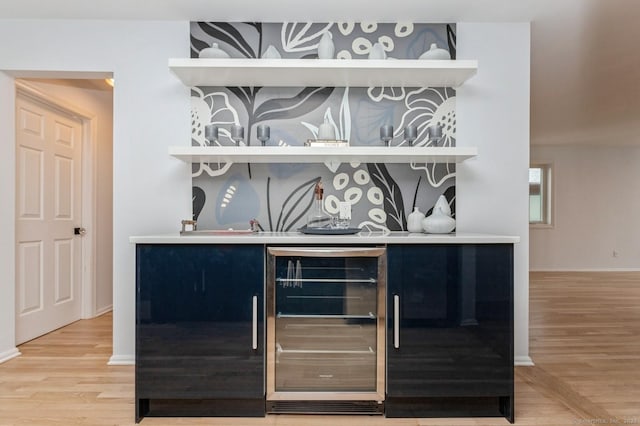 bar featuring beverage cooler and hardwood / wood-style floors