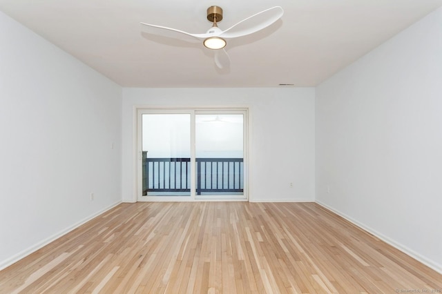 empty room with ceiling fan and light hardwood / wood-style flooring