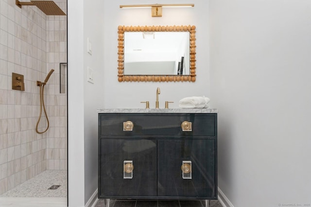 bathroom featuring tiled shower and vanity