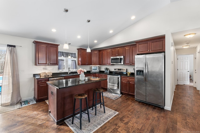 kitchen with sink, decorative light fixtures, appliances with stainless steel finishes, dark hardwood / wood-style flooring, and a kitchen island