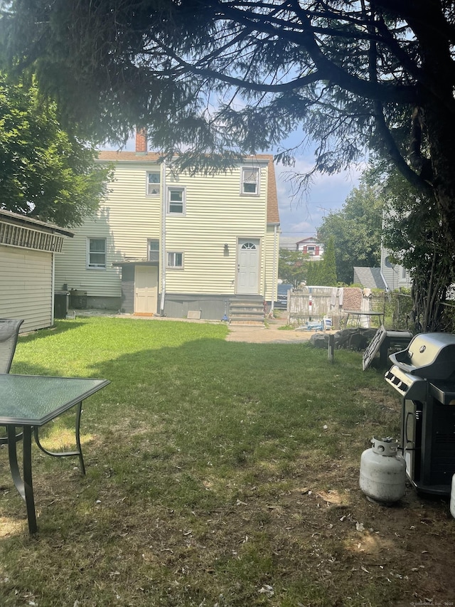 rear view of property featuring a yard