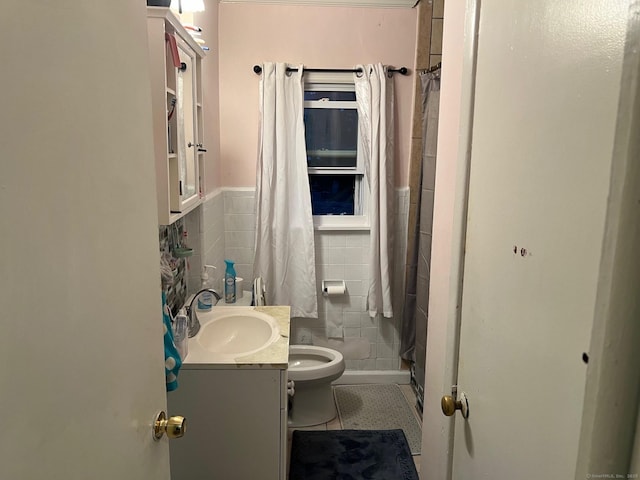 bathroom with tile walls, a shower with shower curtain, vanity, tile patterned floors, and toilet