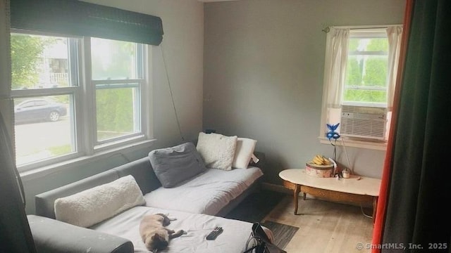 living area featuring wood-type flooring and cooling unit