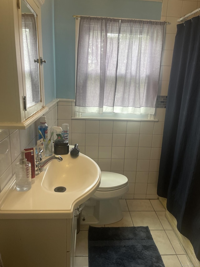 bathroom featuring tile patterned floors, toilet, tile walls, and vanity