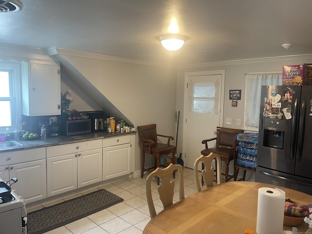 kitchen with white cabinetry, appliances with stainless steel finishes, light tile patterned floors, and crown molding