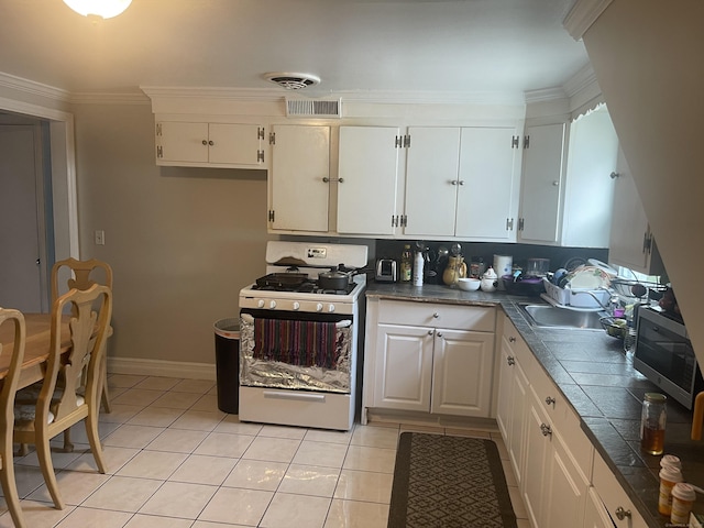 kitchen featuring crown molding, white cabinets, and gas range gas stove