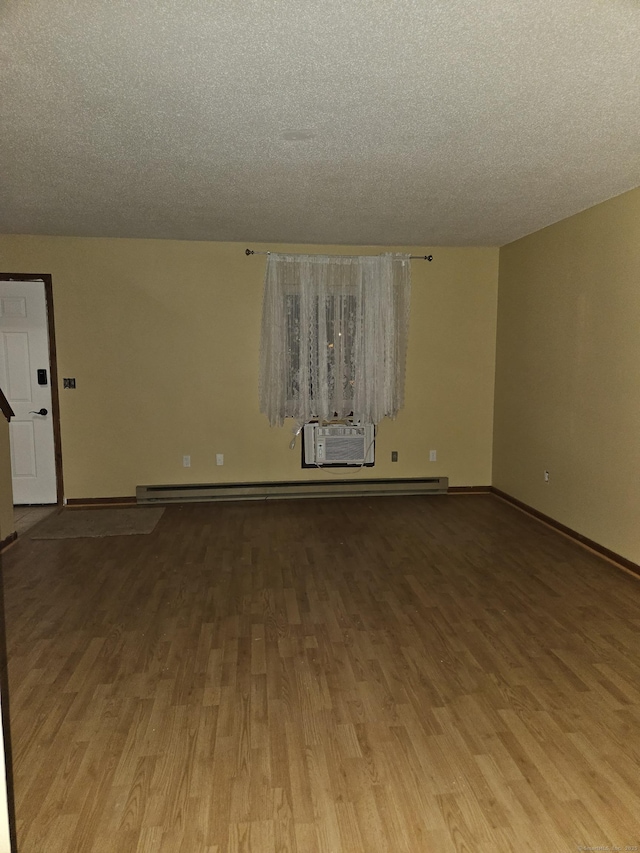 empty room featuring a wall mounted AC, a textured ceiling, and light wood-type flooring