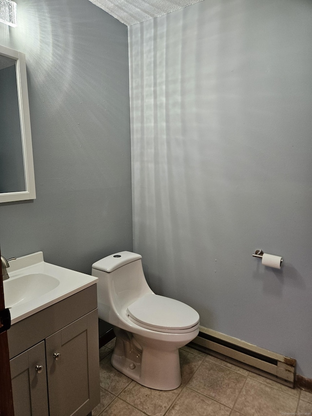 bathroom featuring vanity, a baseboard heating unit, tile patterned floors, and toilet