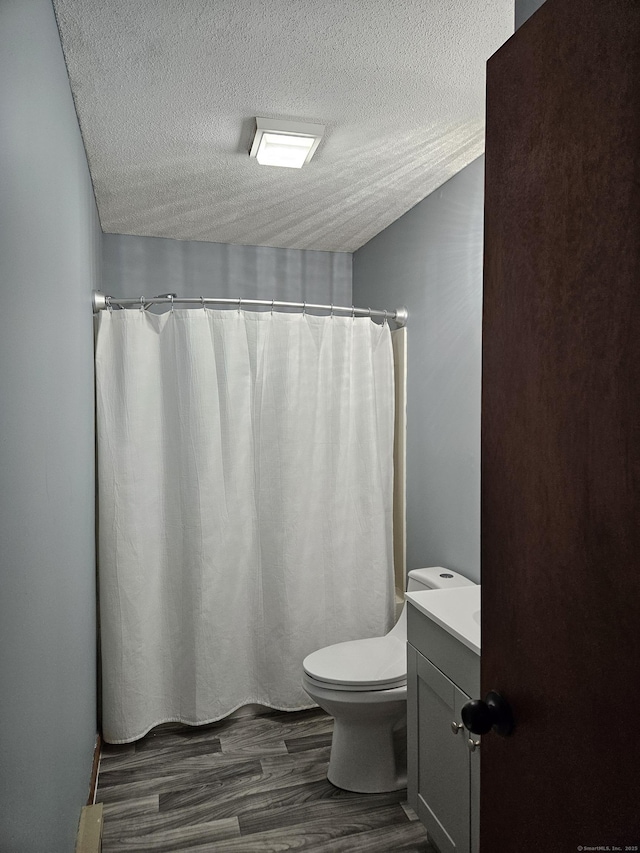 bathroom with vanity, hardwood / wood-style flooring, toilet, and a textured ceiling