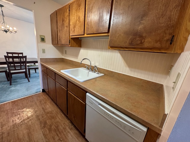 kitchen with sink, an inviting chandelier, decorative light fixtures, light hardwood / wood-style flooring, and white dishwasher