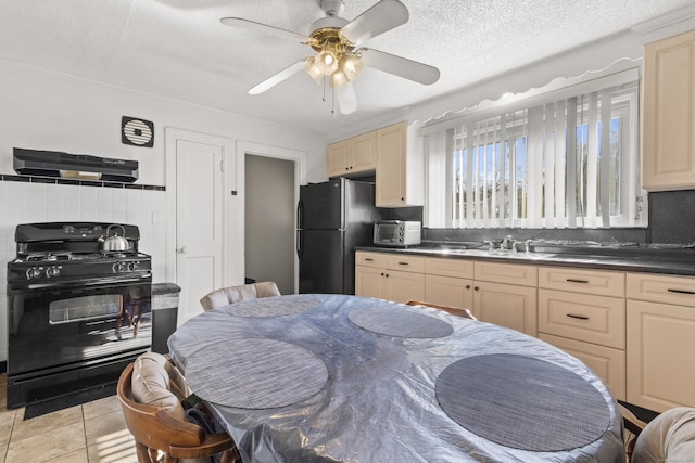 kitchen with light tile patterned floors, ceiling fan, black appliances, a textured ceiling, and decorative backsplash