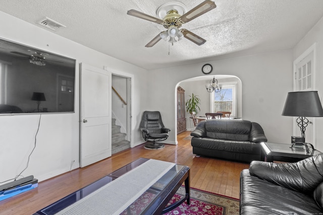 living room with ceiling fan, hardwood / wood-style flooring, and a textured ceiling