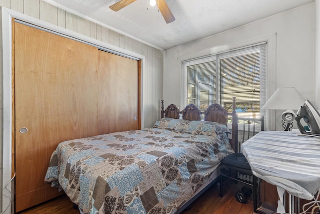 bedroom with ceiling fan, dark hardwood / wood-style floors, a closet, and a textured ceiling