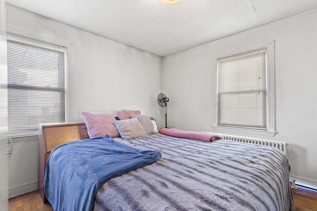 bedroom featuring hardwood / wood-style flooring and a textured ceiling