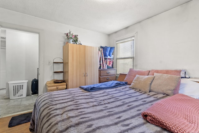 bedroom featuring a textured ceiling and light hardwood / wood-style floors