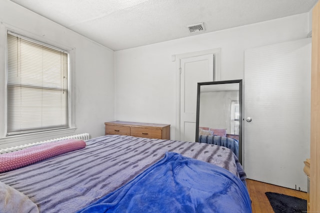 bedroom with hardwood / wood-style flooring and a textured ceiling