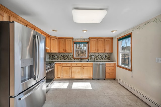 kitchen featuring baseboard heating, stainless steel appliances, tasteful backsplash, and a wealth of natural light